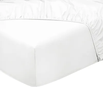 A close-up view of a white fitted sheet on a mattress.
