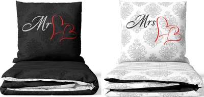 Two folded bedding sets, one black and one white, are displayed side-by-side against a white background. Each set includes a pillow and a folded duvet or comforter.