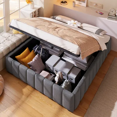 A bed with its storage compartment open, revealing various items inside, in a bedroom setting.