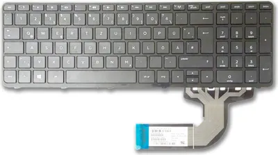 A black QWERTZ German keyboard with a ribbon cable attached.
