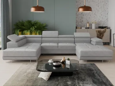 A modern living room with a large sectional sofa, coffee table, and plants.