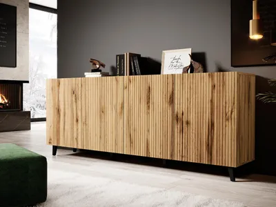 A modern living room with a fireplace, a green ottoman, and a wooden sideboard.