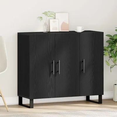 A black wooden sideboard with three doors and metal legs, placed against a white wall with some decorative items on top.