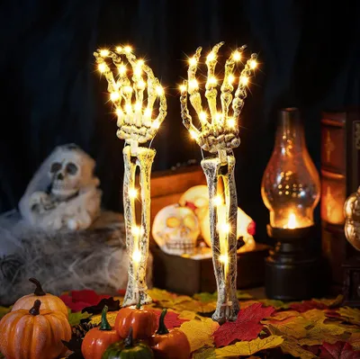 Halloween decorations including skeleton hands with lights, pumpkins, and skulls.