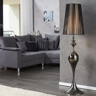 A modern living room with a grey sectional sofa and a tall floor lamp.