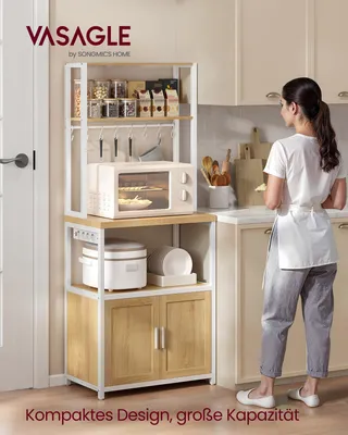 A woman stands in a kitchen next to a multi-tiered kitchen shelf unit.