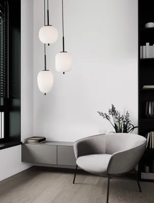 A modern living room with a chair, cabinet, and pendant lights.