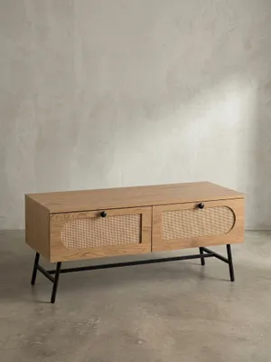 Frontansicht des TV-Schranks mit Eiche-Dekor, zwei Rattan-Schubladen und schwarzen Metallbeinen, freigestellt vor weißem Hintergrund._#sku_SAFWL6.889#