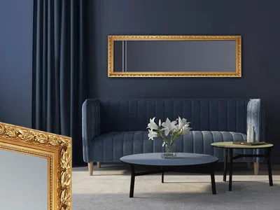 A living room scene with a blue sofa, coffee table, and a gold-framed mirror on the wall.