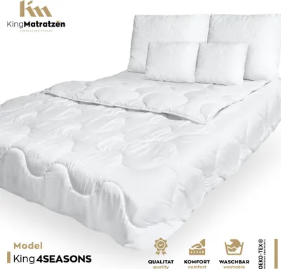 A white duvet and pillows are arranged on a bed, presented against a white background.
