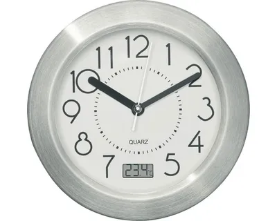 A close-up view of a round, silver-framed clock with a white face, black numbers, and black hands. It also displays a digital temperature reading.