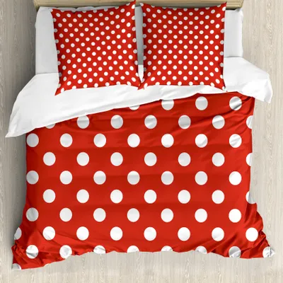 A top-down view of a red polka dot duvet cover and matching pillowcases on a bed.