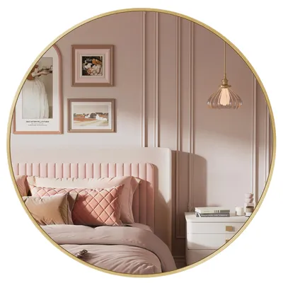 A bedroom scene reflected in a round mirror, showing a bed, pillows, and wall decor.