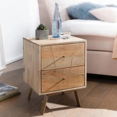 A wooden nightstand with two drawers is placed next to a bed. A bottle of water and a glass are on top of the nightstand, along with a small potted plant.