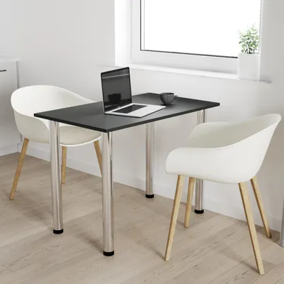 A small dining table with two chairs in a bright room with a window.