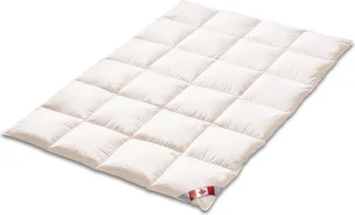 A white down comforter is laid out flat on a white background, with a small Canadian flag tag visible on one corner.