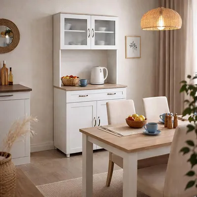 A dining room scene featuring a white kitchen buffet with glass doors and a wooden countertop, next to a dining table set for a meal.