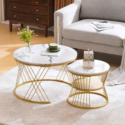 A living room setting with two marble-look coffee tables, a sofa, and a dresser.