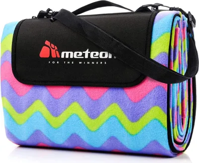 A rolled-up picnic blanket with a zigzag pattern and a black carrying strap and flap with a logo.