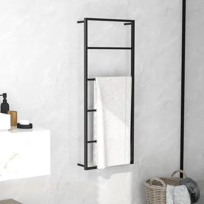A black towel rack with a white towel hanging on it, placed on a marble-patterned wall next to a sink.