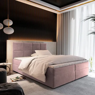 A bedroom scene with a pink boxspring bed as the focal point, decorated with soft lighting and curtains.