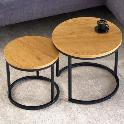 Two round nesting coffee tables on a carpet.