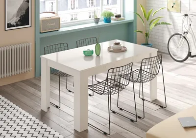 A dining table and chairs set in a bright, modern dining room with a window and plants.