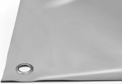 A close-up view of a gray PVC tarp with a metal grommet.