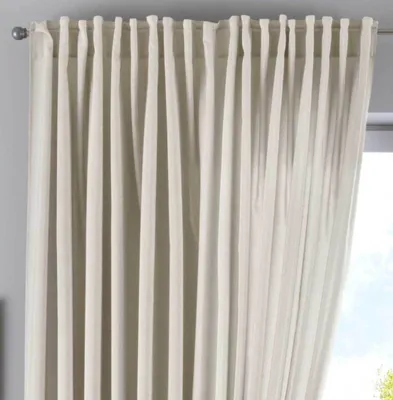 A close-up view of a light-colored curtain hanging from a rod.