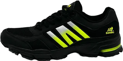 A side view of a single black athletic shoe with neon green and silver accents.