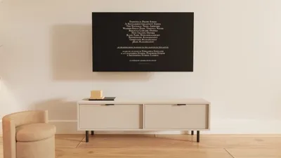A modern living room with a TV cabinet and artwork on the wall.