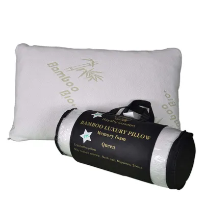 A white pillow is shown next to its rolled-up packaging, which is black with gold and white text.