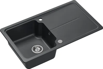 A dark gray granite kitchen sink with a drainboard is shown from a diagonal angle.
