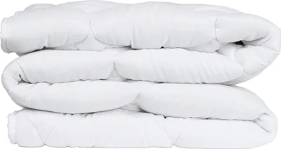 A white quilted blanket folded into three layers and stacked on top of each other against a white background.