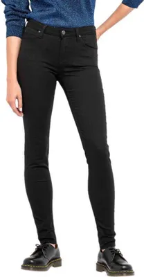 A person wearing black skinny jeans and black shoes, shown from the waist down.