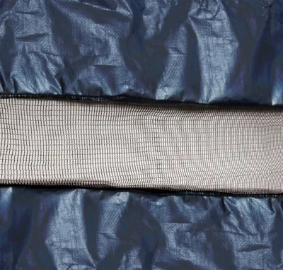 A close-up view of a dark blue tarp with a beige mesh strip in the middle.