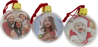 Three clear Christmas ornaments with photos of families and babies inside, each with a red ribbon and gold cap.