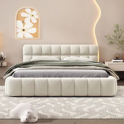 A bedroom scene featuring a bed with a headboard and footboard, dressed with bedding and a throw blanket. A piece of abstract art hangs on the wall above the bed, and a small decorative object is placed on the floor in front of the bed.