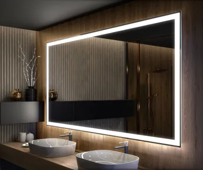 A modern bathroom with a large illuminated mirror above two sinks.