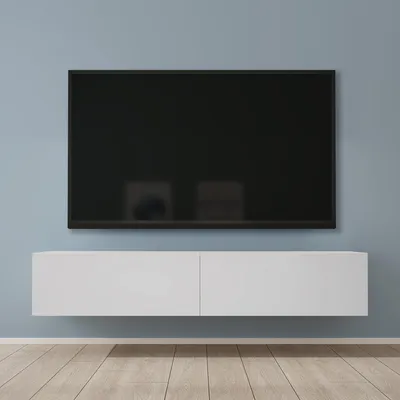 A wall-mounted TV stand with a television above it, set against a light blue wall and a wooden floor.