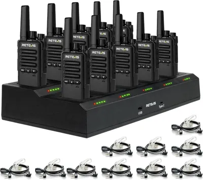 A set of walkie-talkies and their charging station, along with individual earpieces, are displayed on a black surface.