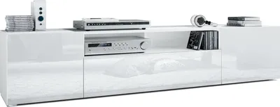 A white, modern TV stand with electronic equipment and decorative items on top.