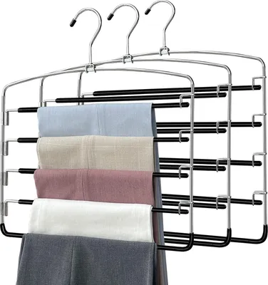 A multi-tiered hanger with several pairs of pants folded over it.