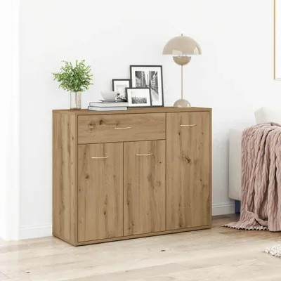 A wooden sideboard with drawers and doors, decorated with framed pictures and a lamp on top, in a room setting.