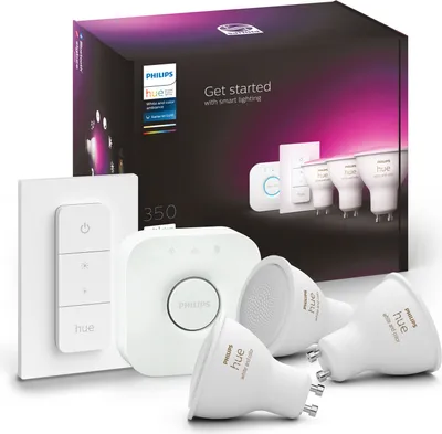A product box for Philips Hue smart lighting, with various components displayed in front of it.