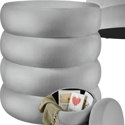 A stack of round, gray ottomans, with the bottom one open to reveal storage.