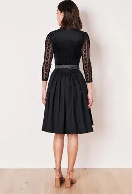 A woman is shown from the back wearing a black dirndl dress.
