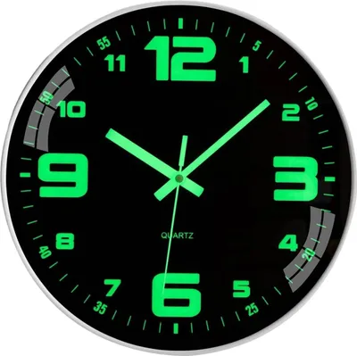 A close-up shot of a black analog wall clock with glowing green numbers and hands.