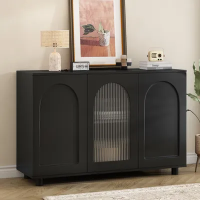 A black sideboard with arched doors and a fluted glass door is displayed in a room setting.