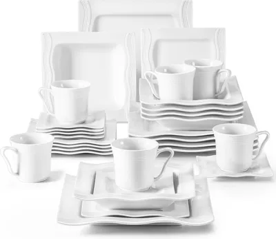 A collection of white ceramic dinnerware, including plates, bowls, and cups, arranged in stacks.